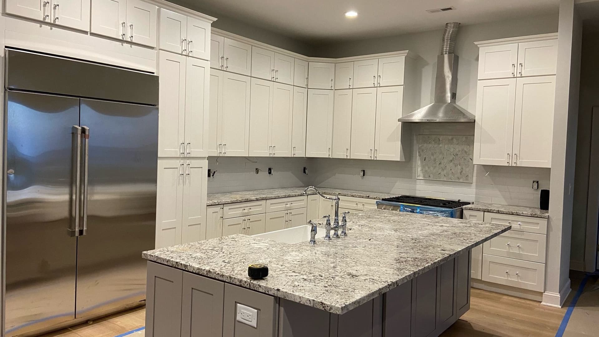 Finished kitchen remodel with white shaker cabinetry and a granite island by GM 5.0 Construction